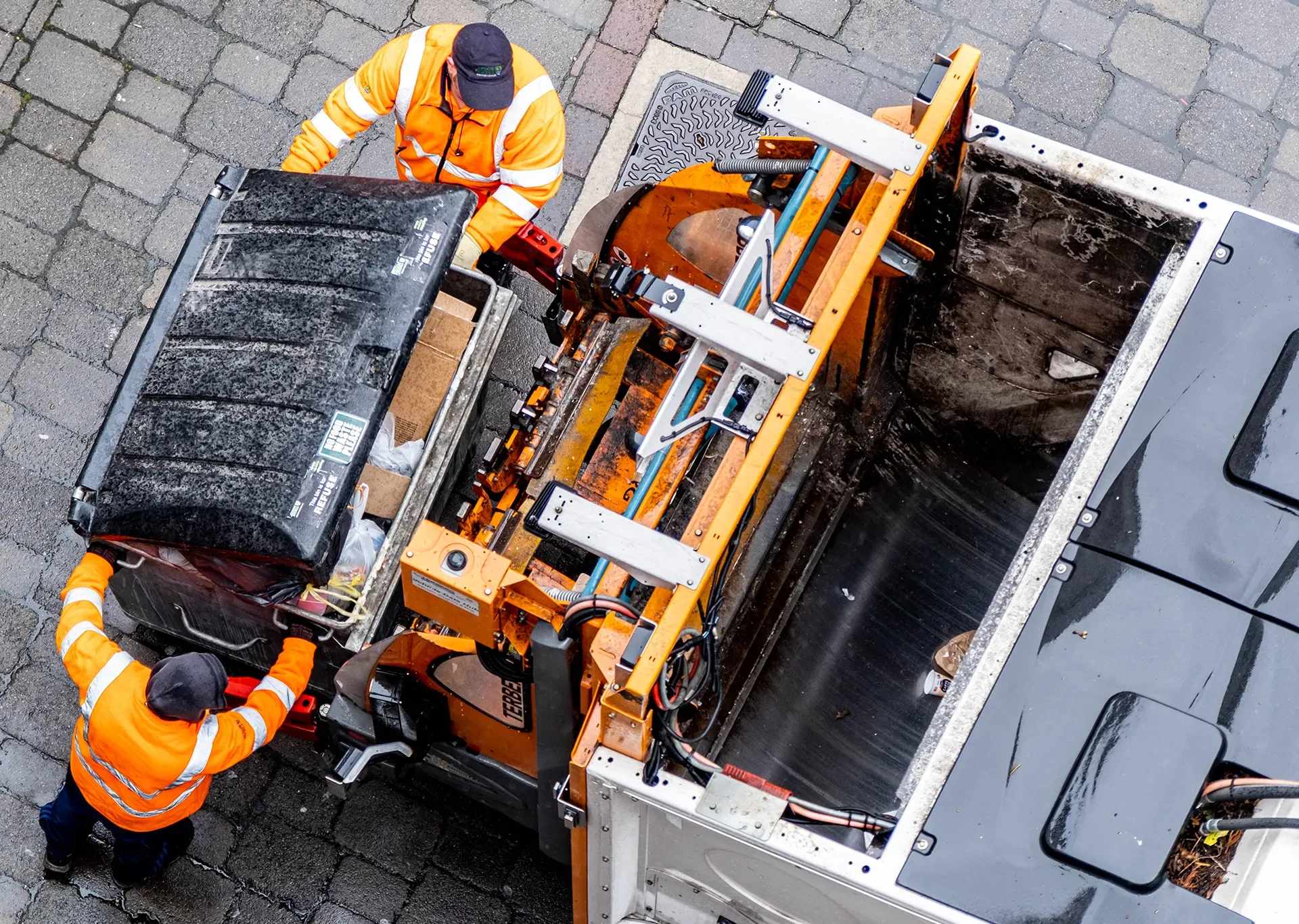 Bin men loading a bin into a waste recycling truck